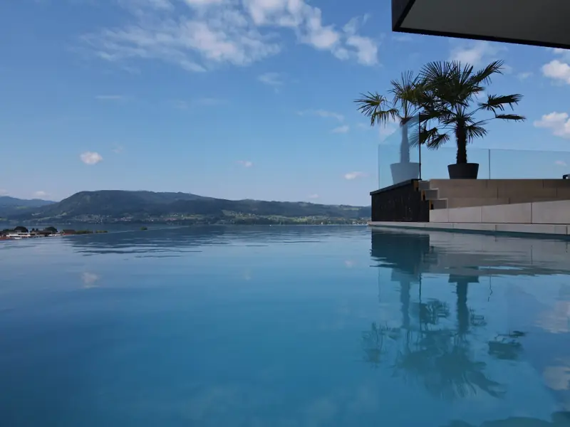 Überlaufpool, dessen Wasserfläche nahtlos in den Attersee übergeht